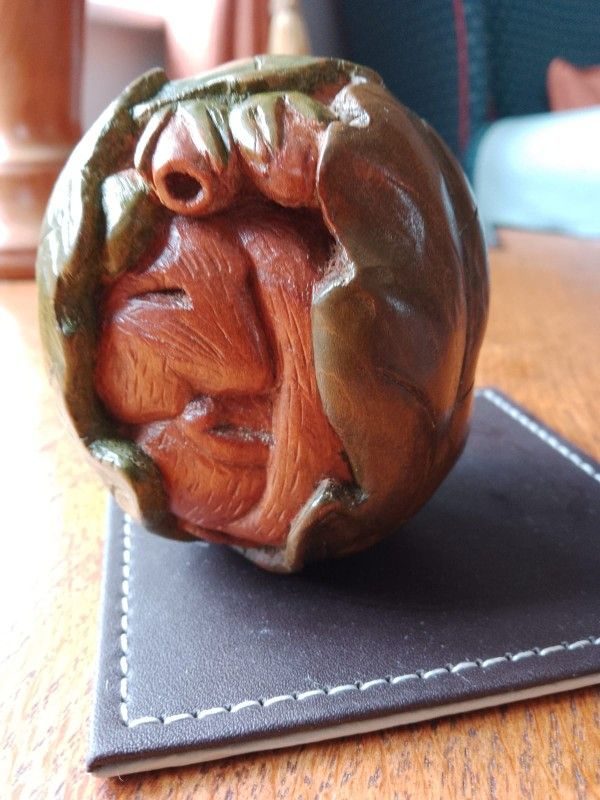 Round carving with a sleeping dormouse curled inside